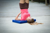 girl doing shoulderstand on platform