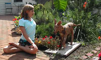 girl doing twist next to dog statue